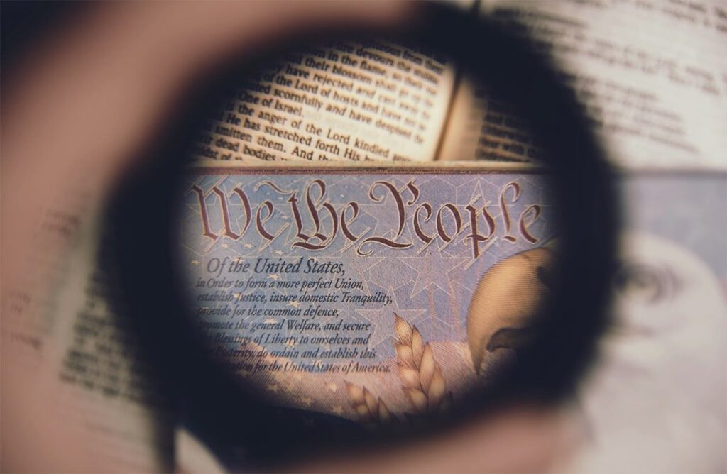 Magnifying glass on passport showing "We the People..." and eagle