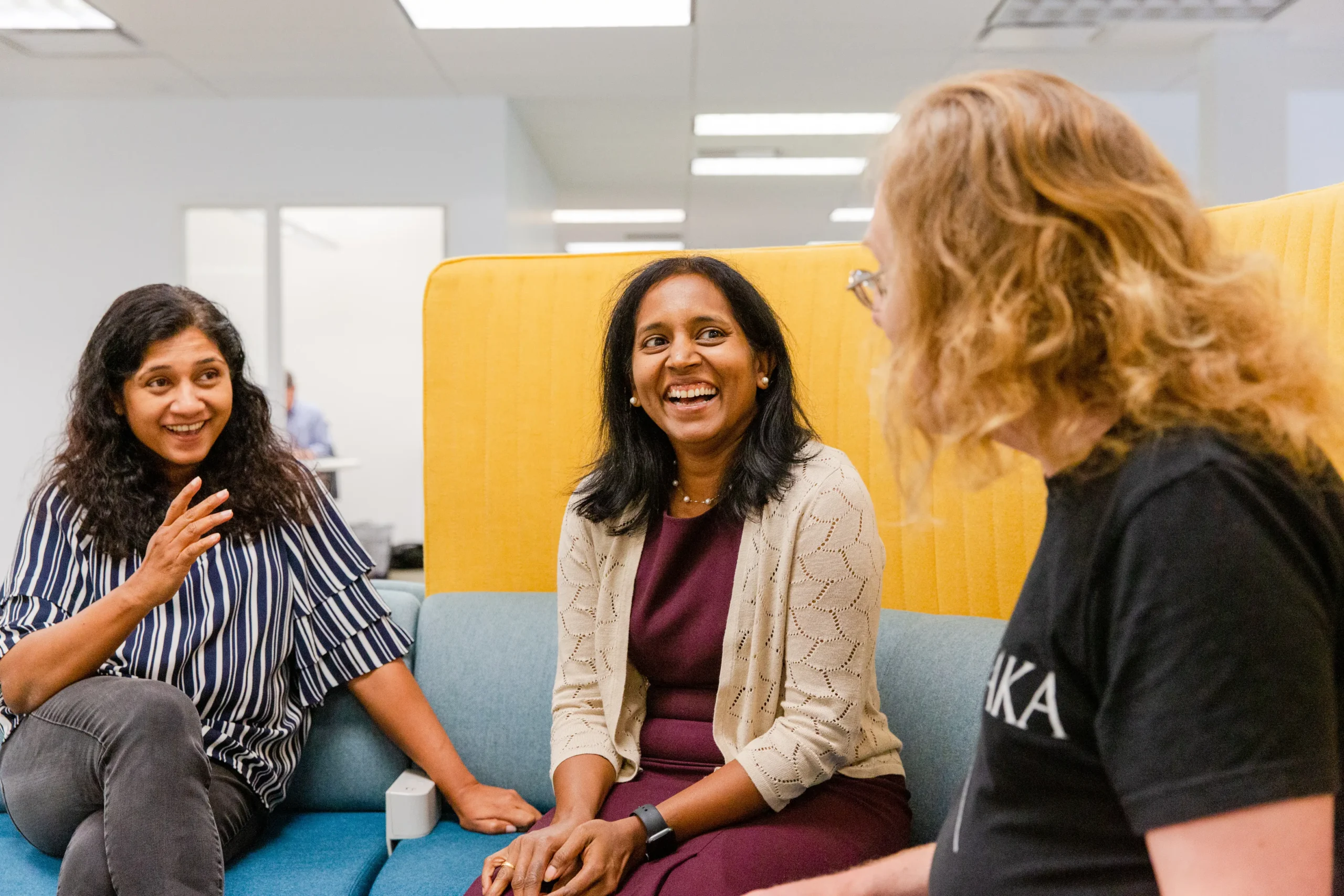 Three people speaking in an office