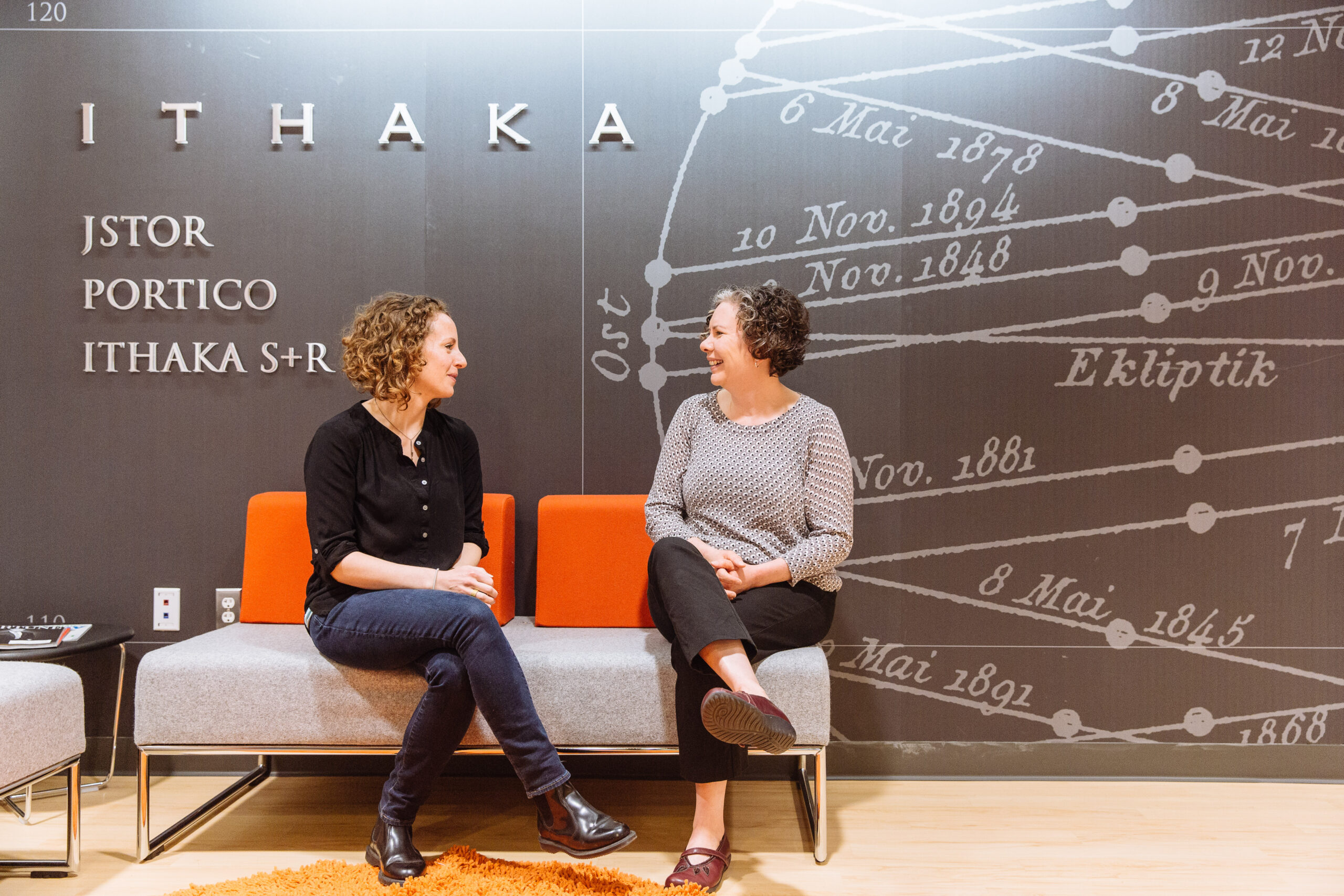 Two staff members chatting in ITHAKA's Ann Arbor office lobby