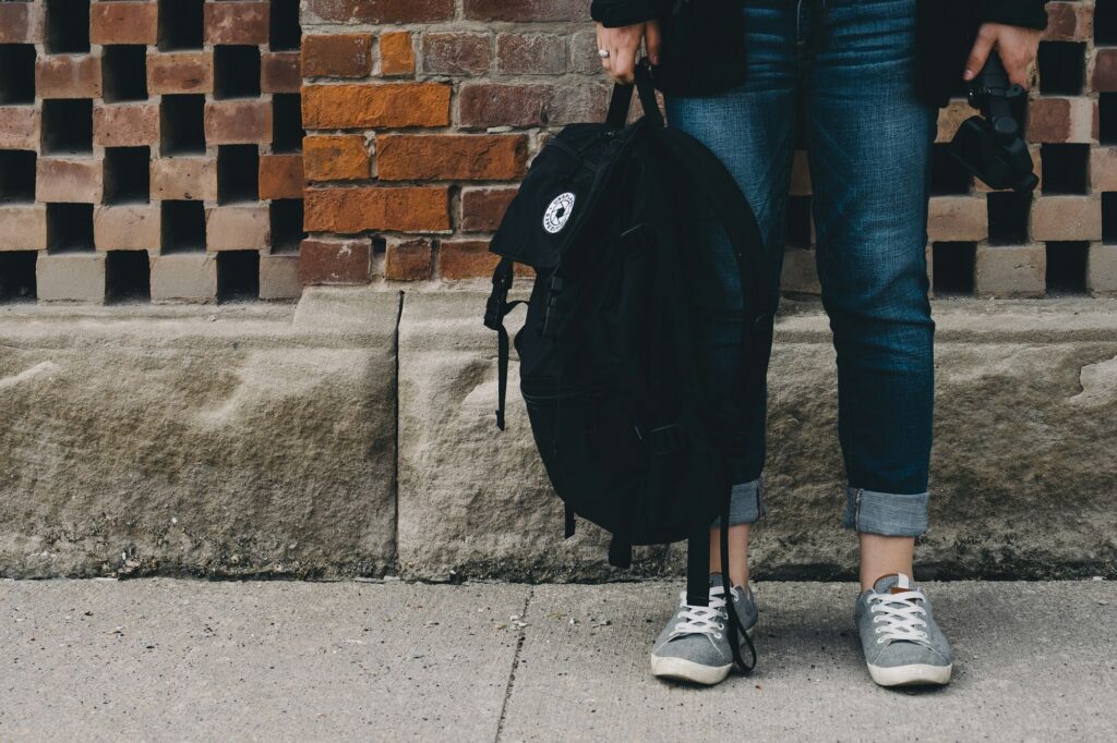 Student with backpack standing on sidewalk